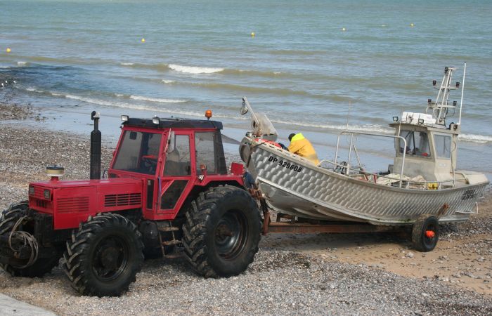 Le tracteur sort le bateau de l'eau et le ramène sur le perré.